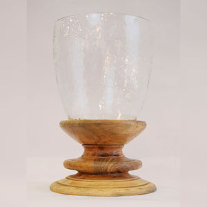 Candelabro decorativo con base de madera y recipiente de vidrio, diseño cálido para mesas o repisas.