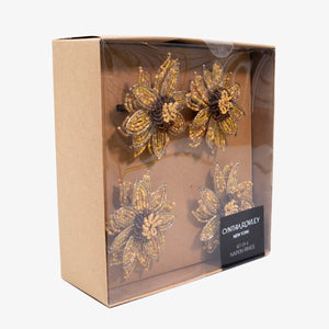 Set de servilleteros dorados en forma de girasol, diseño bordado en pedrería elegante para decoración de mesa.