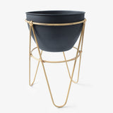 Matera con base en palos de bamboo, y base negra. Esta matera es ideal para usar en el patio o jardín,  tus flores serán las protagonista de tu decoración. 