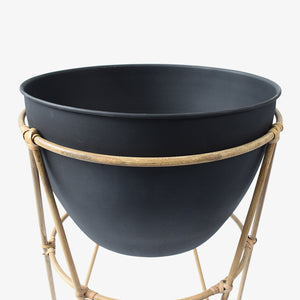 Matera con base en palos de bamboo, y base negra. Esta matera es ideal para usar en el patio o jardín,  tus flores serán las protagonista de tu decoración. 