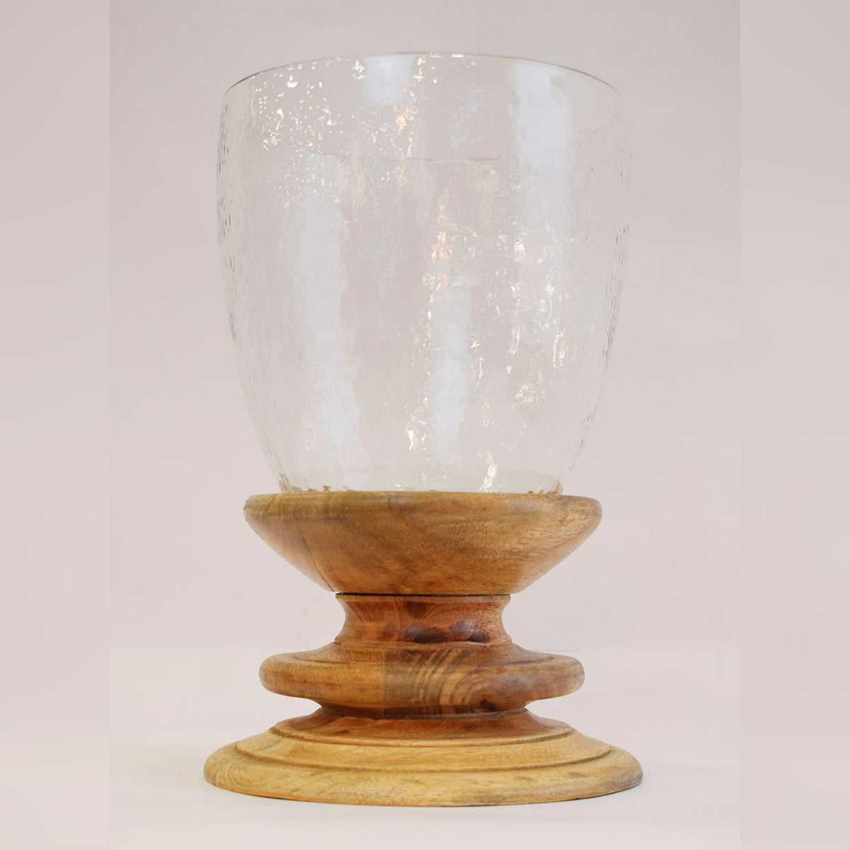 Candelabro decorativo con base de madera y recipiente de vidrio, diseño cálido para mesas o repisas.