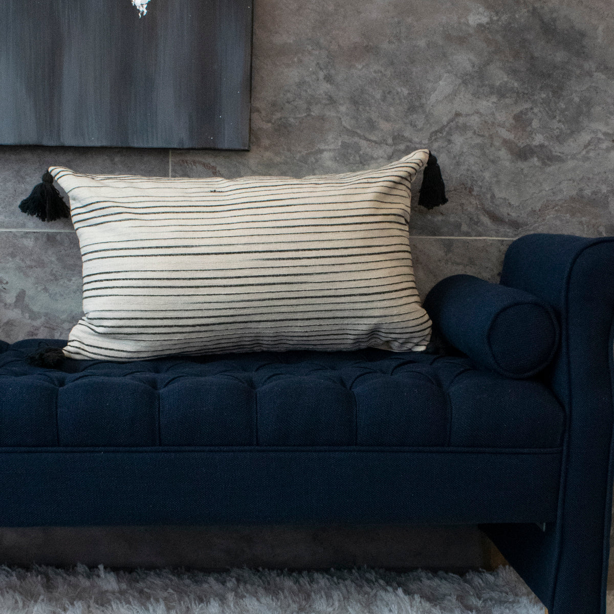 cojín rectangular beige con rayas negras y pompones relleno de pluma vertihome