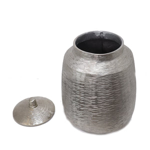 Jarrón decorativo plateado con tapa metálica, diseño moderno para almacenamiento o decoración. 