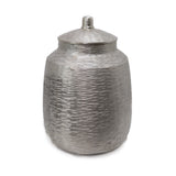 Jarrón decorativo plateado con tapa metálica, diseño moderno para almacenamiento o decoración.