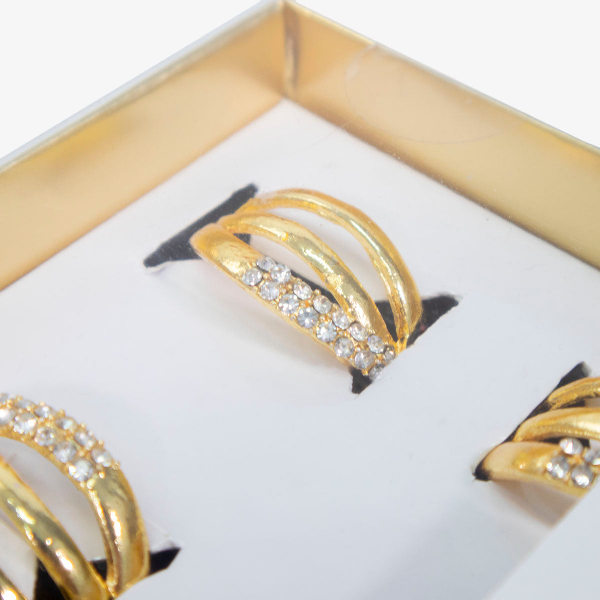 Set de servilleteros de anillos dorados en metal inoxidable, diseño elegante para decoración de mesa.