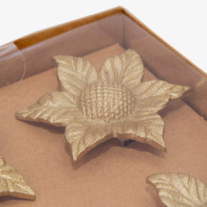 Set de servilleteros dorados en forma de girasol, diseño metálico elegante para decoración de mesa.