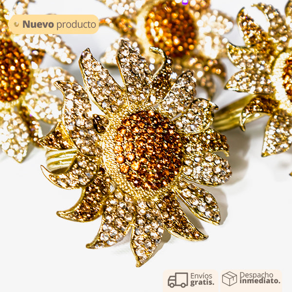 Set de servilleteros en forma de flor dorada con pedrería, diseño elegante y tropical para decoración de mesa.